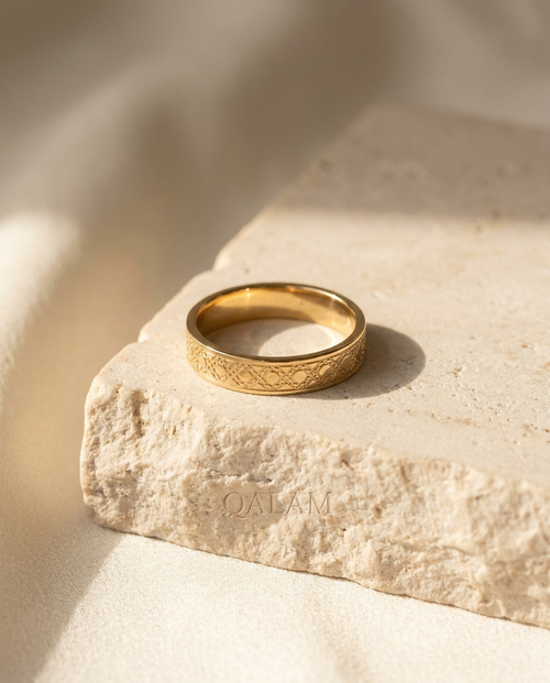 Girih Band — 18k gold ring with engraved girih lattice, on cream stone